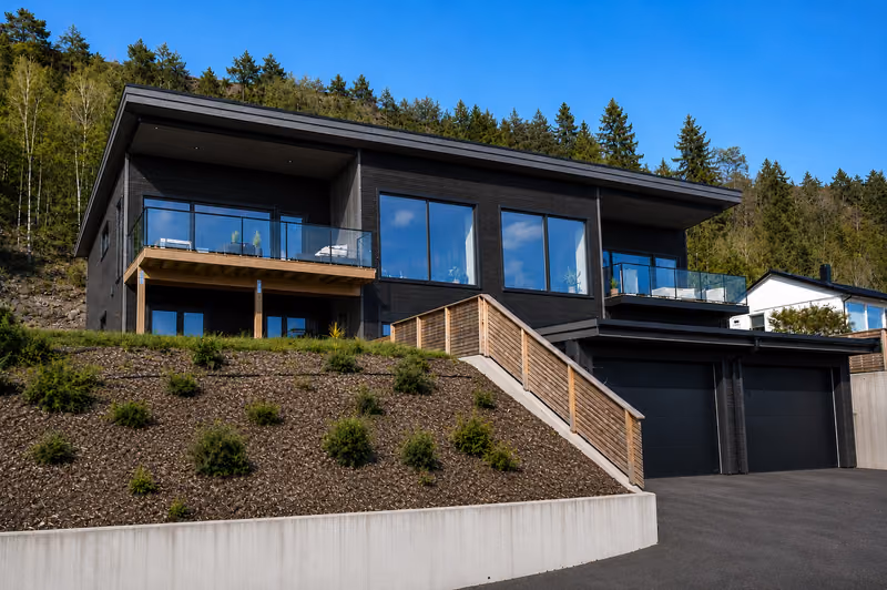 The Hoffland duplex seen from the driveway, with a garage on the lower floor and steps up to the entrance